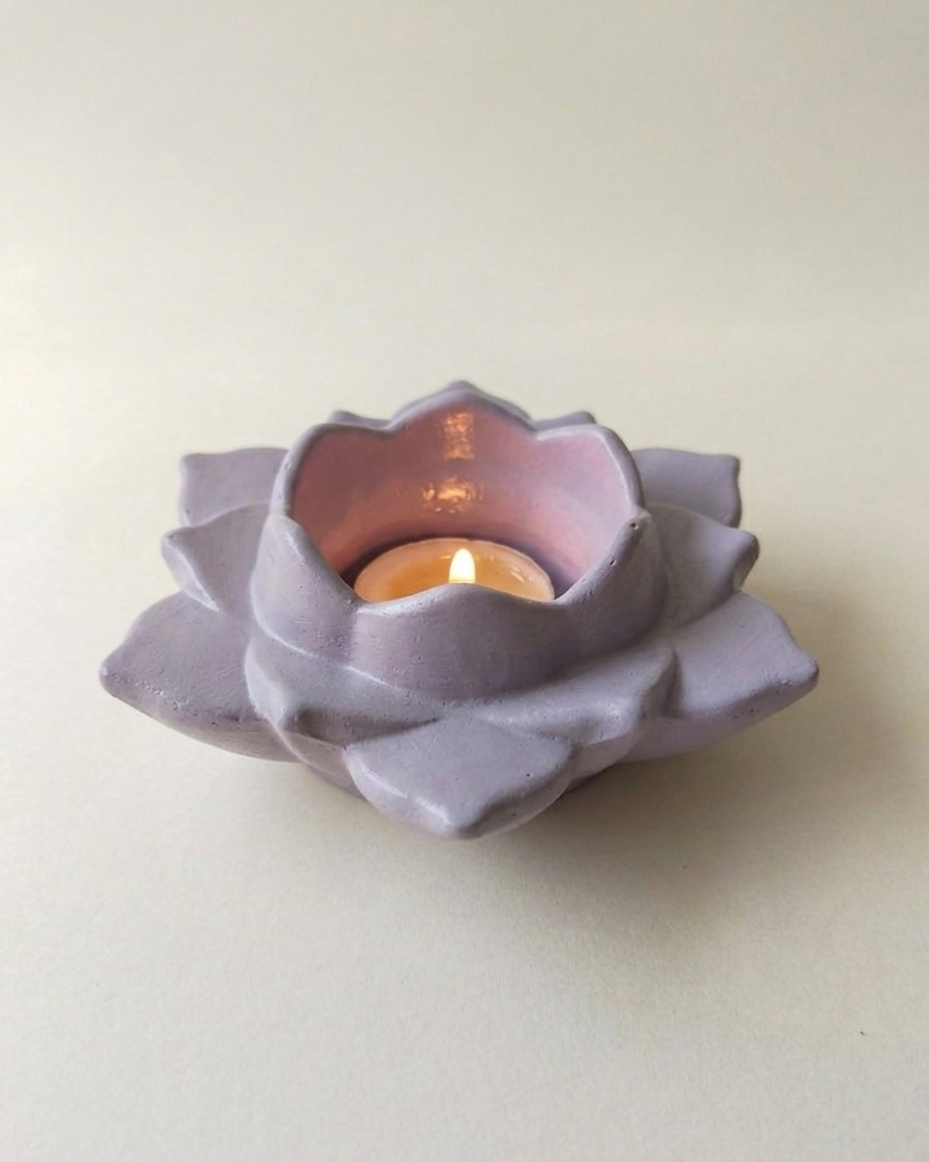 Lavender ceramic lotus tealight holder, lit, hero shot