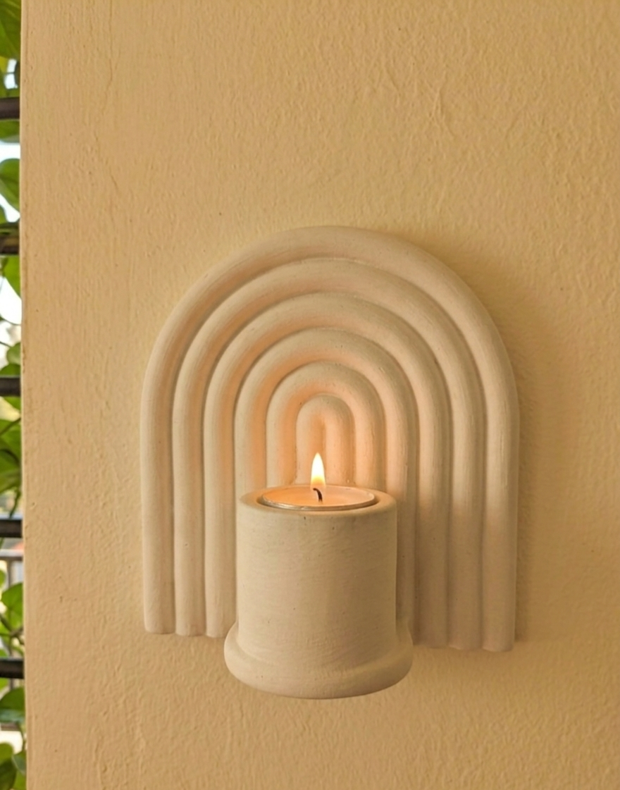 Lumen nested arch ceramic candle sconce mounted on a wall, lit